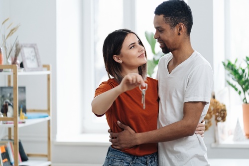 happy-young-couple-holding-new-house-key-indoors-2021-12-09-13-26-32-utc-1